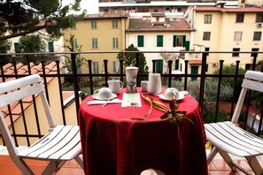 A balcony with a red tablecloth, white chairs, and a coffee setup. - Hotel Villa Il Castagno (Florence)