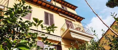 A multi-story building with balconies and shutters.