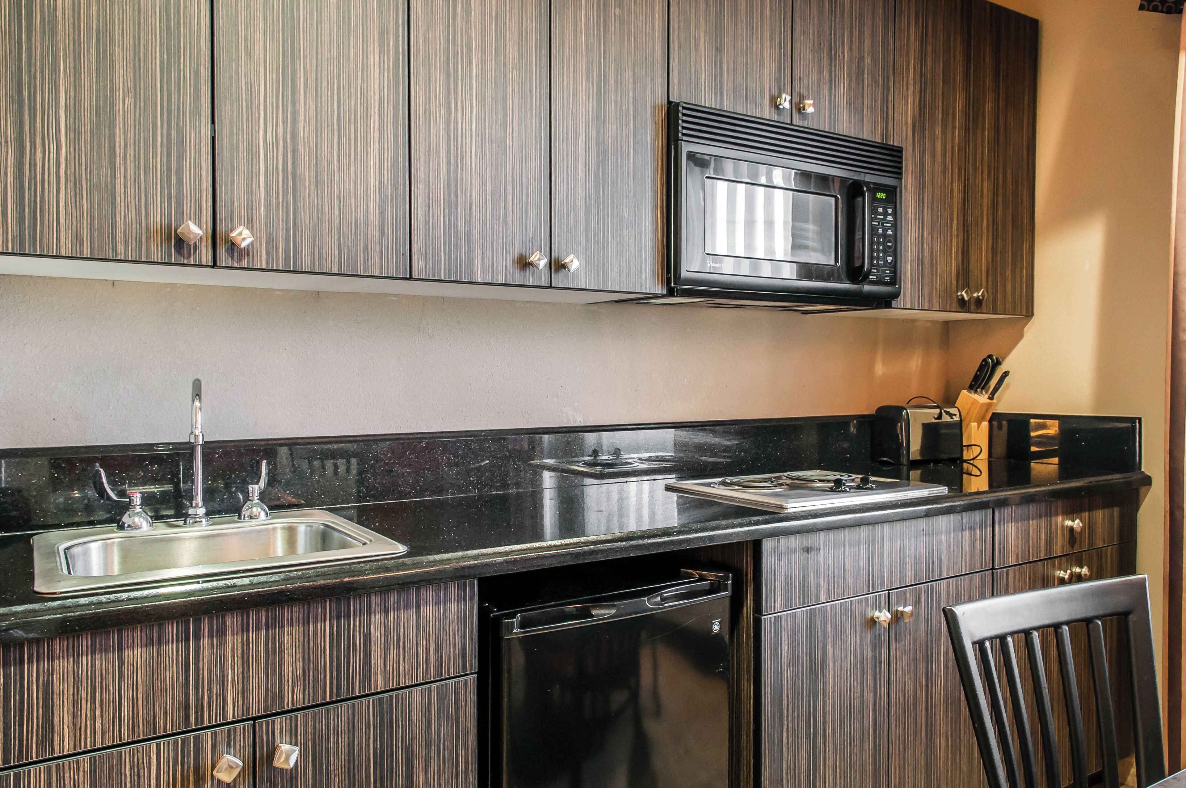 A kitchen with a built-in microwave, stainless steel sink, and dishwasher.