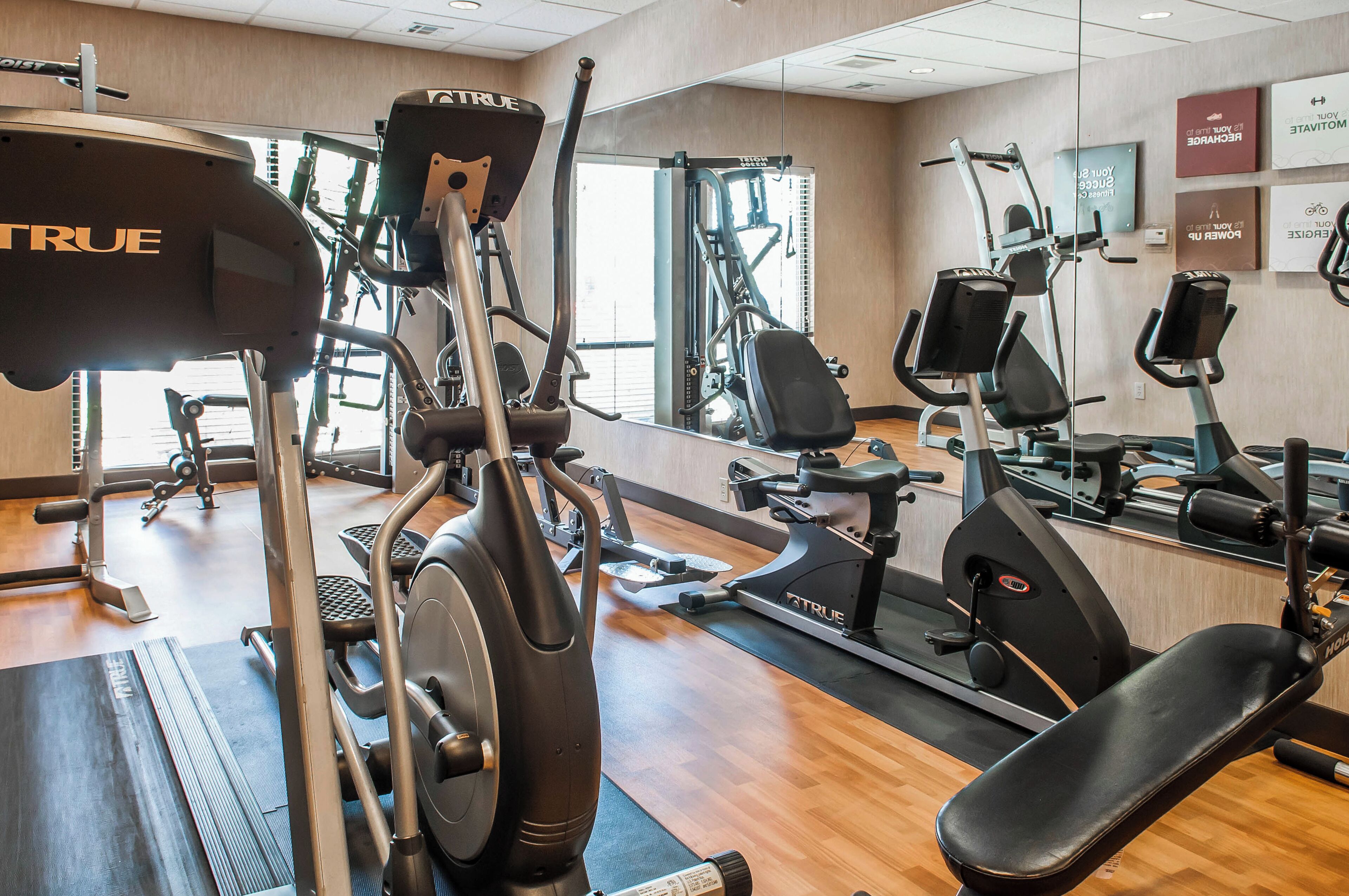 Un gimnasio equipado con cintas de correr, bicicletas estáticas y máquinas de pesas.