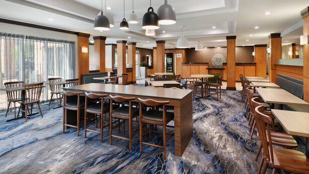 A hotel lobby with a large reception desk, multiple seating areas, and a patterned carpet. - Fairfield Inn & Suites by Marriott Fort Pierce (Fort Pierce)