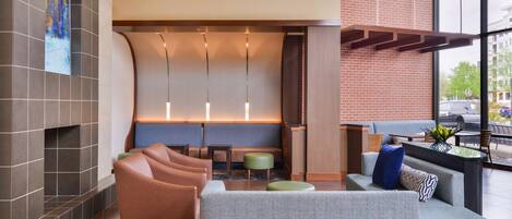 A modern lobby with a seating area, a fireplace, and a view of the outdoors.
