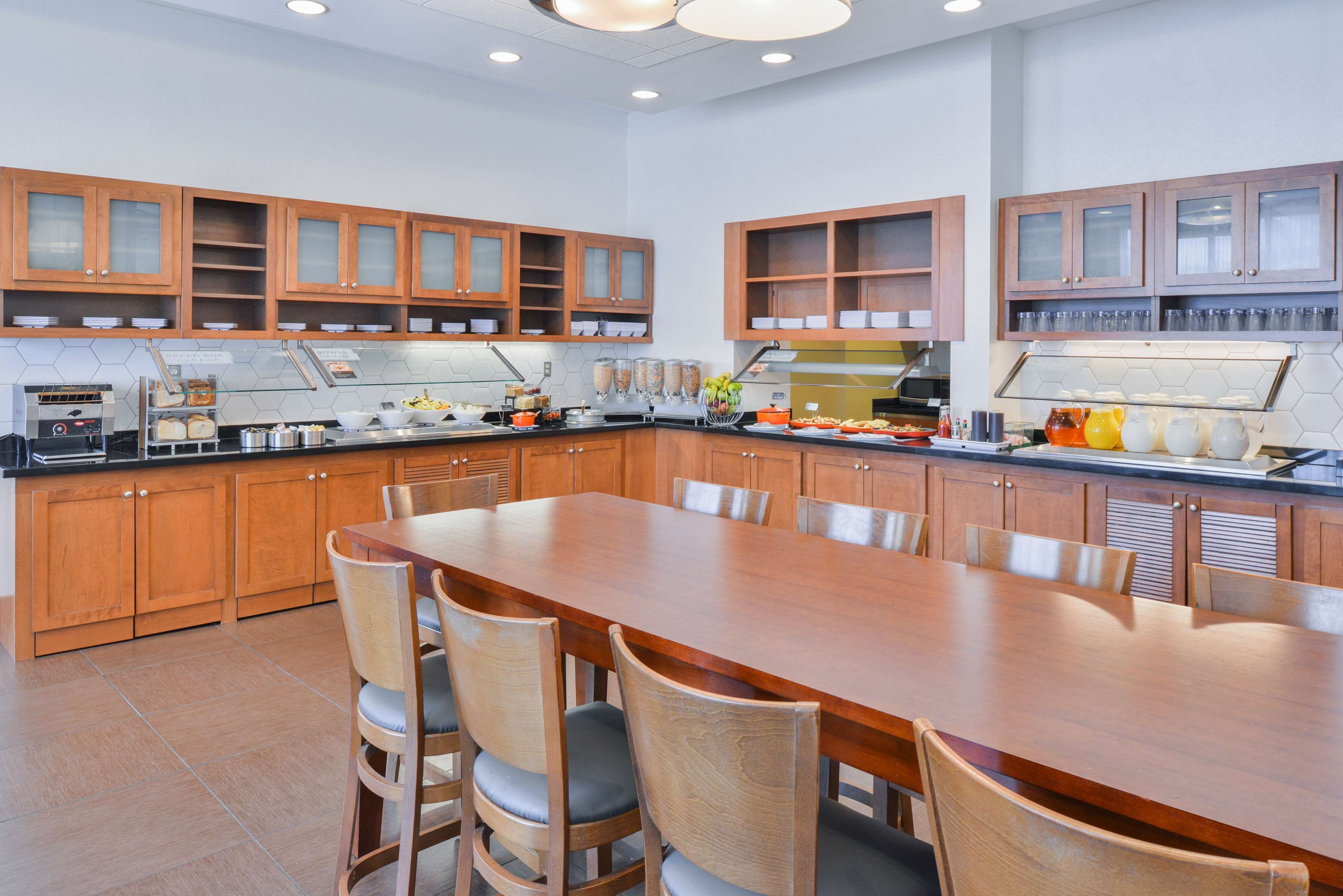Una cocina moderna con armarios de madera, una mesa de comedor grande y varios electrodomésticos.