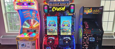 Tres máquinas de arcade en una sala con ventanas amplias.