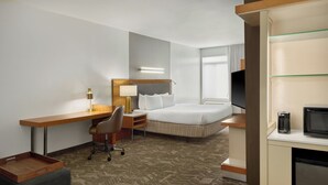 A hotel room with a bed, desk, chair, TV, and a small kitchenette. - SpringHill Suites by Marriott Detroit Metro Airport Romulus (Romulus)