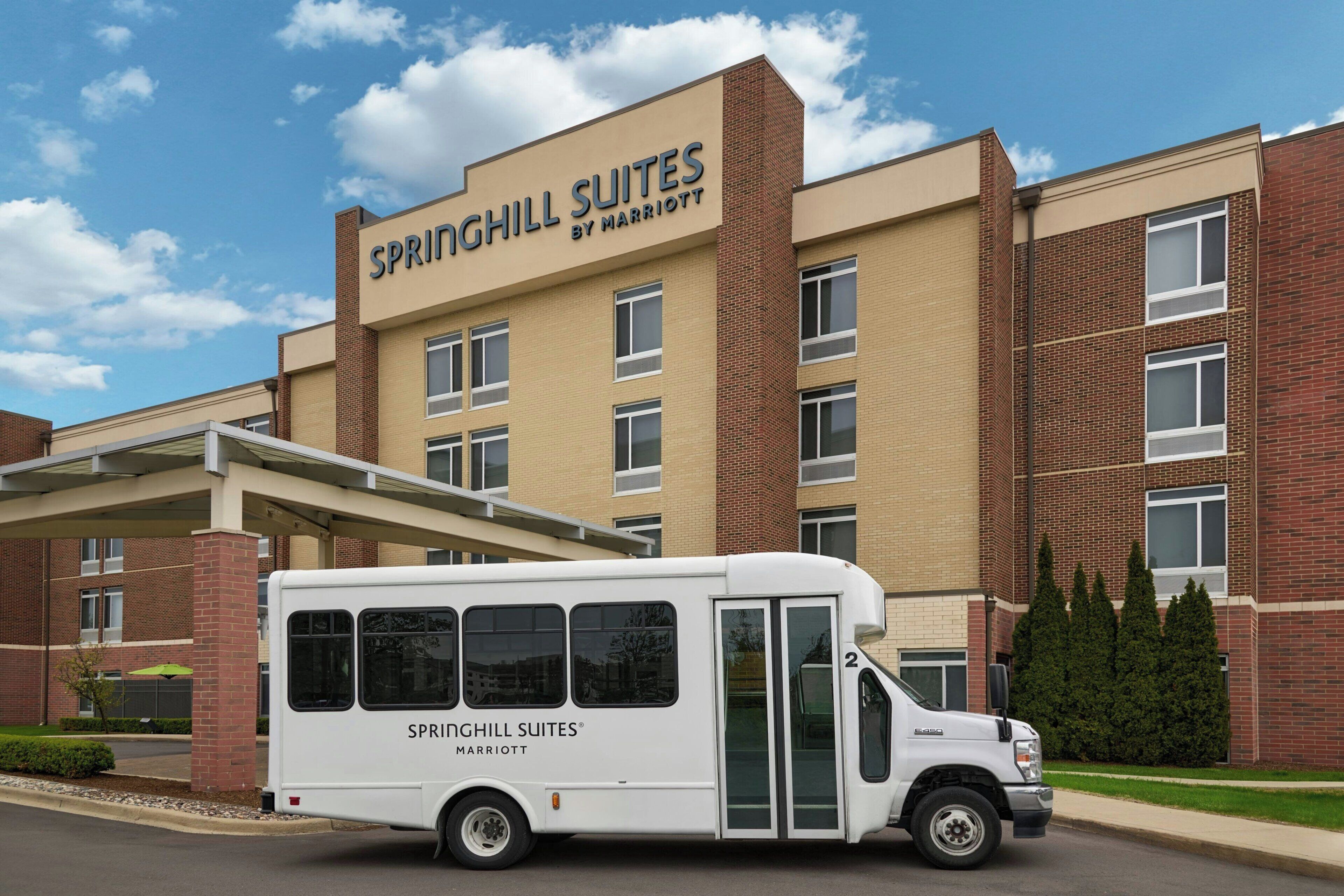 Ein weißes Hotelgebäude der Sprinchill Suites Marriott mit einem weißen Lieferwagen davor.