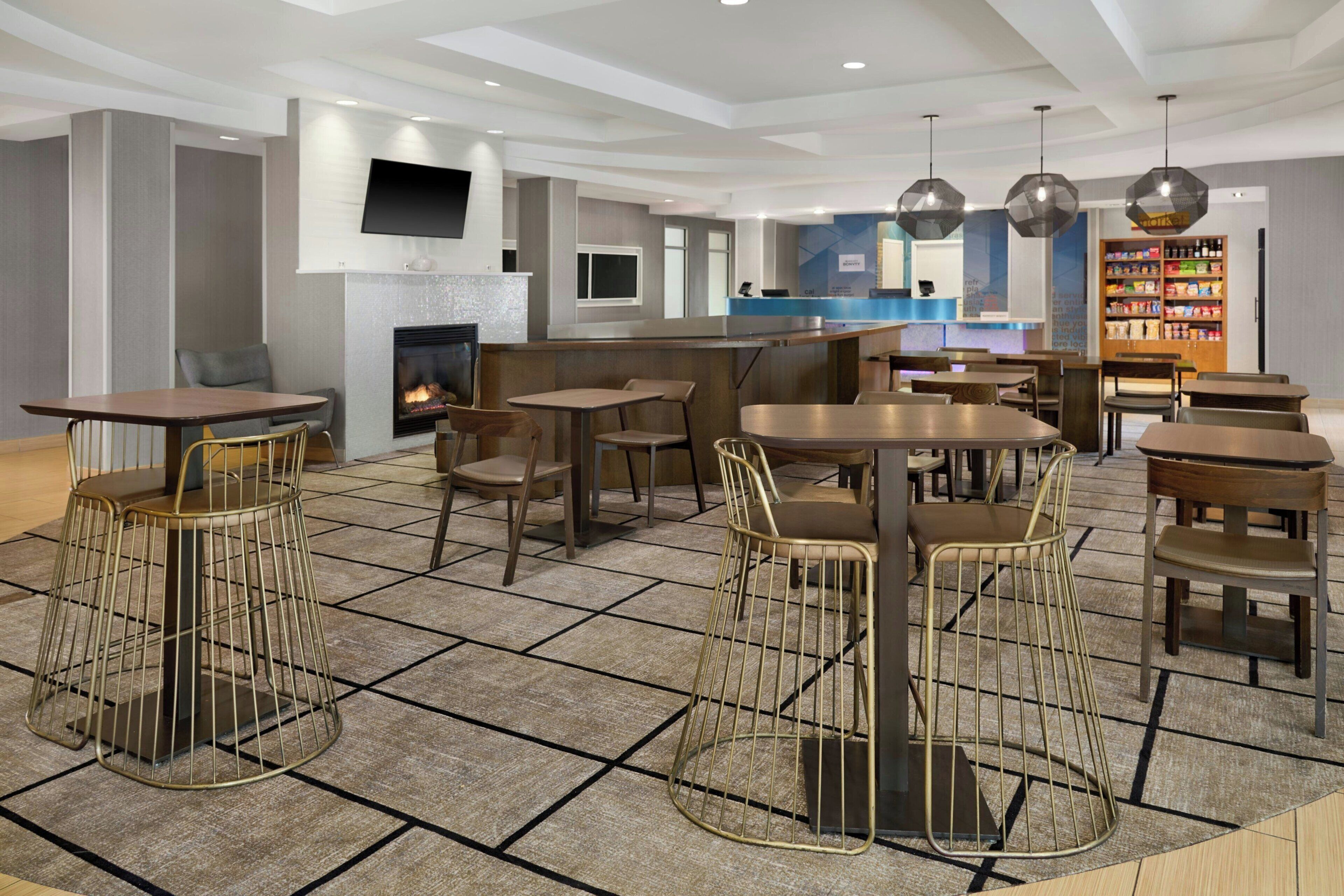 Un interior moderno con chimenea, varias zonas de estar y un bar.