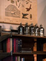 Uma estante de madeira com livros e garrafas de vidro.
