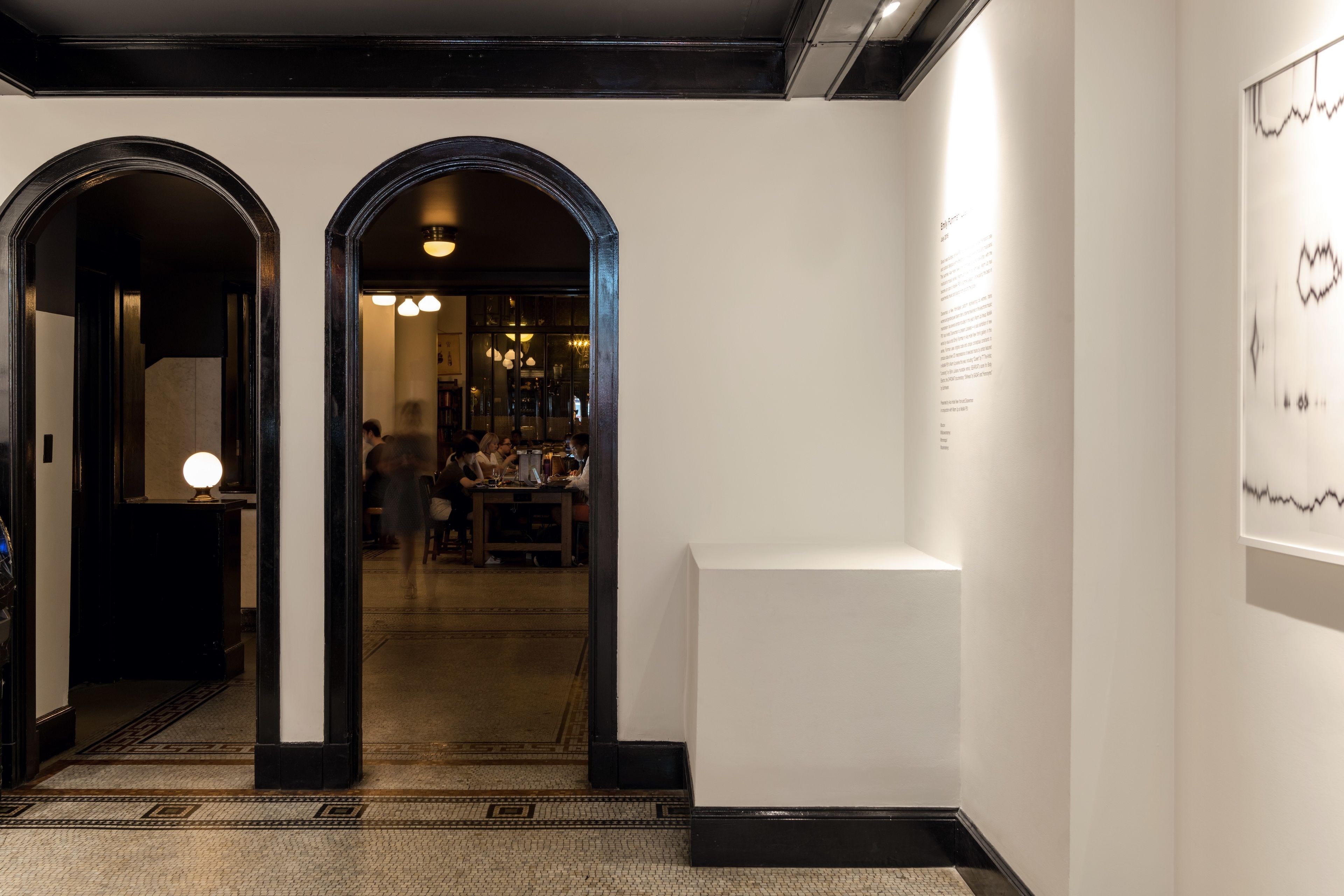 A hallway with two arched doorways leading to a dining area.