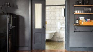 Et moderne badeværelse med badekar, toilet og bruseniche.