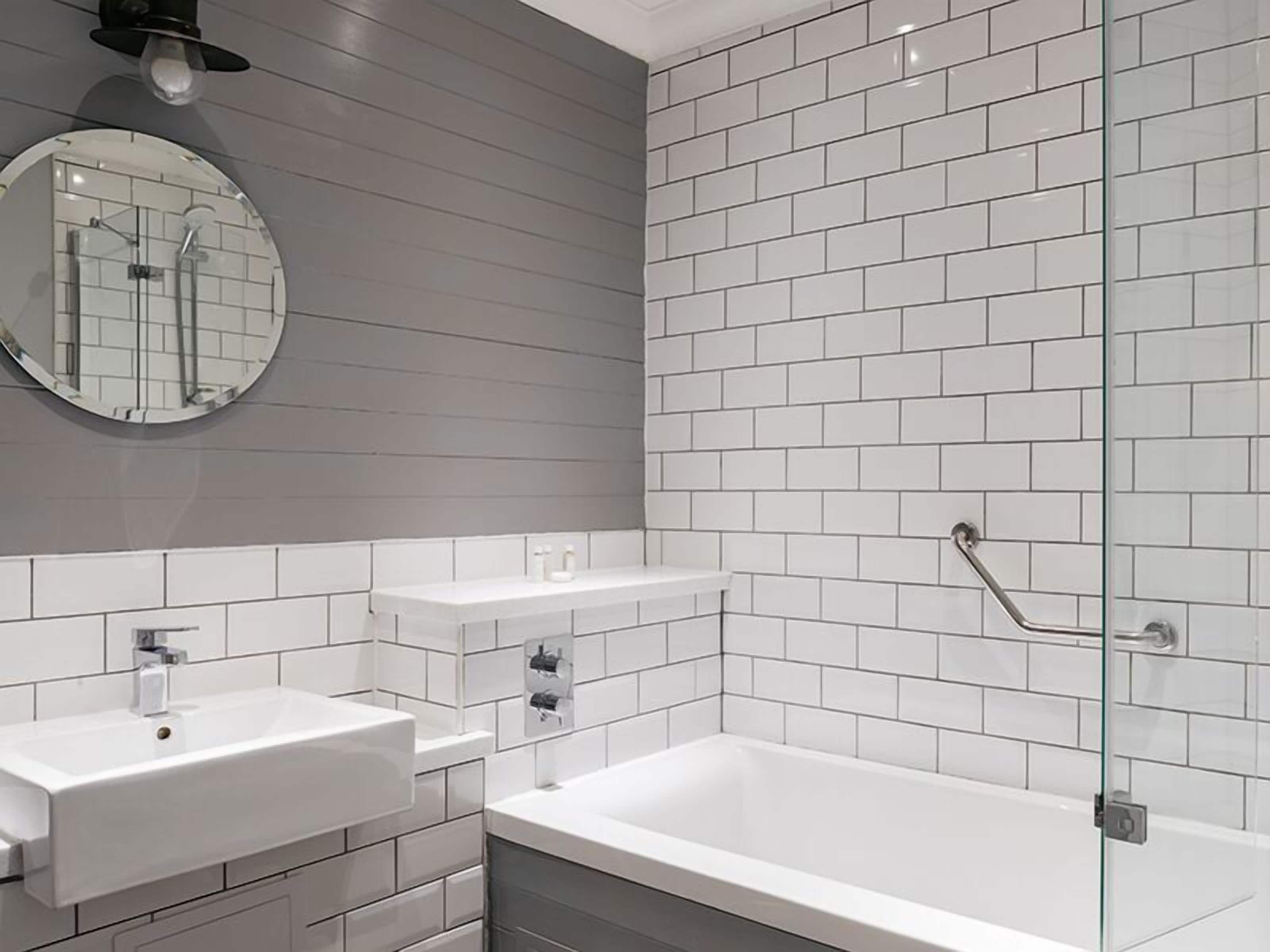 Un baño moderno con una bañera grande, dos lavamanos y zona de ducha.