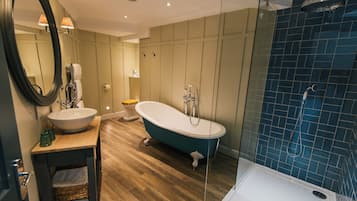 Un baño moderno con una bañera independiente, una ducha con cerramiento de vidrio y un lavabo con espejo.