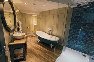 Un baño moderno con una bañera independiente, una ducha con cerramiento de vidrio y un lavabo con espejo.