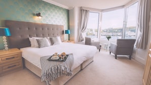 Una camera d'albergo con un letto grande, vista sulla città e una finestra con tende.