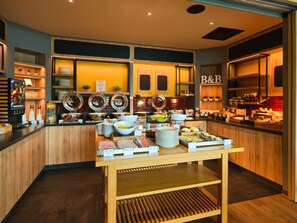 A buffet setup with various food items and condiments on display.