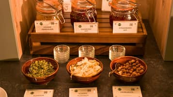 Una exhibición de alimentos con frascos de mermelada y recipientes con semillas y frutos secos.