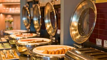 A buffet setup with multiple food containers and serving utensils.