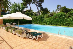 Alberca techada, alberca al aire libre y sombrillas en la alberca