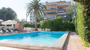 Piscine couverte, piscine extérieure, parasols de plage, chaises longues