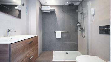 Un baño moderno con ducha, inodoro y tocador.