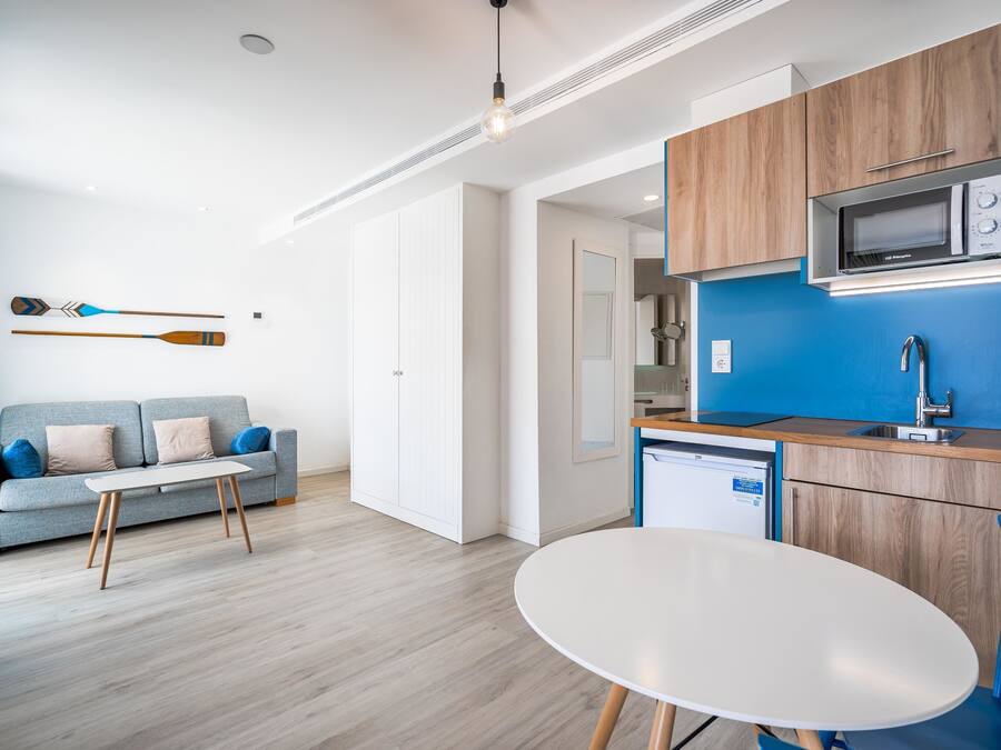 A modern kitchen with wooden cabinets, a microwave, and a sink.