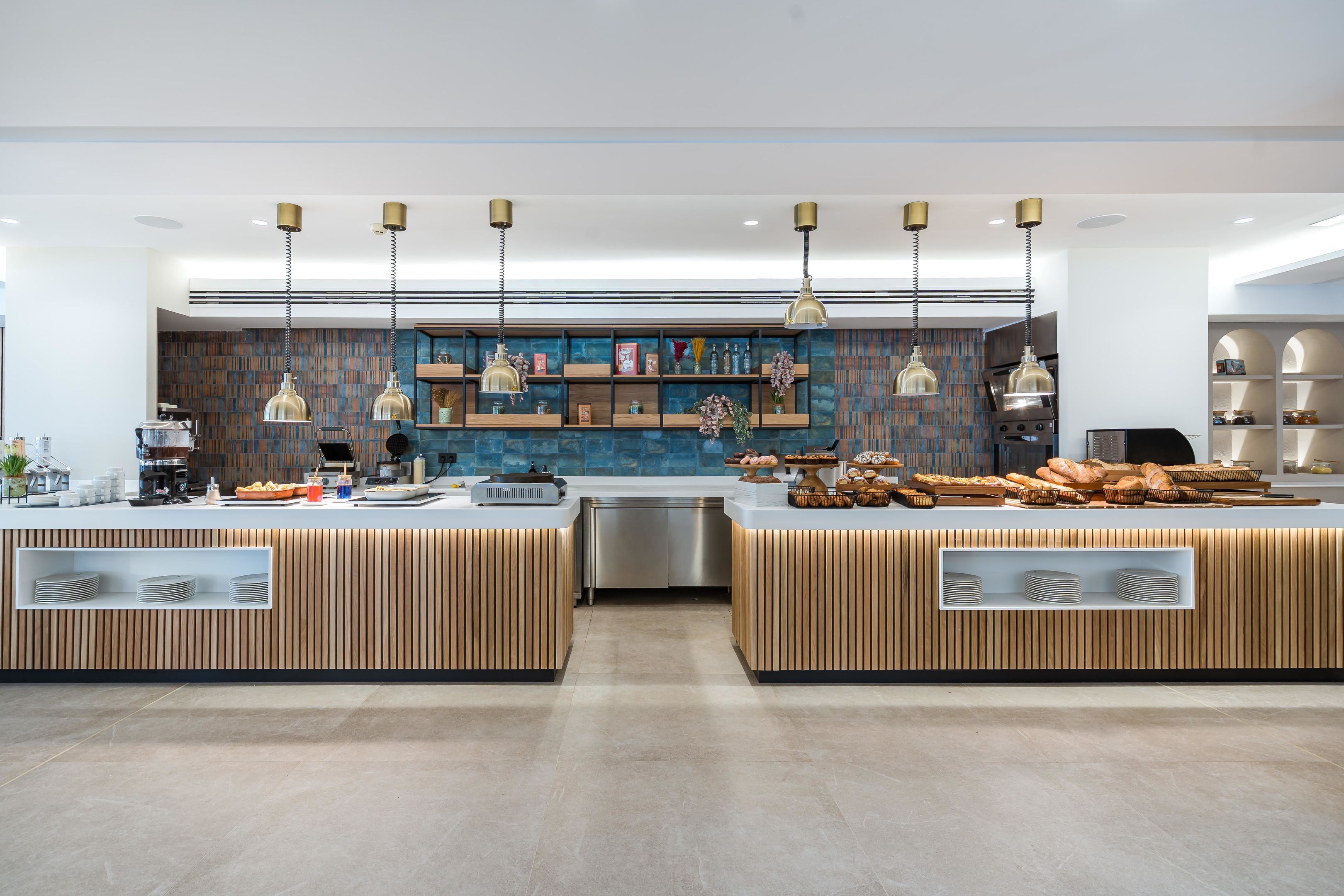 Una cocina moderna con detalles de madera, electrodomésticos de acero inoxidable y una isla central con productos expuestos.