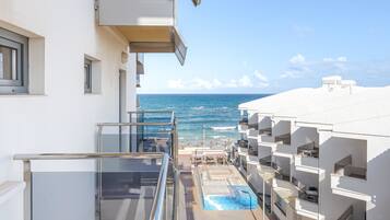 A modern hotel with a balcony overlooking the ocean.