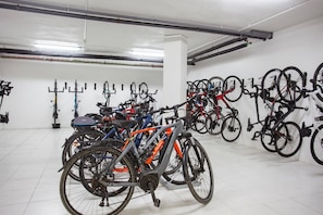 A bike storage area with multiple bicycles parked against the wall. - THB Gran Bahia Hotel and Apartments (Santa Margalida)