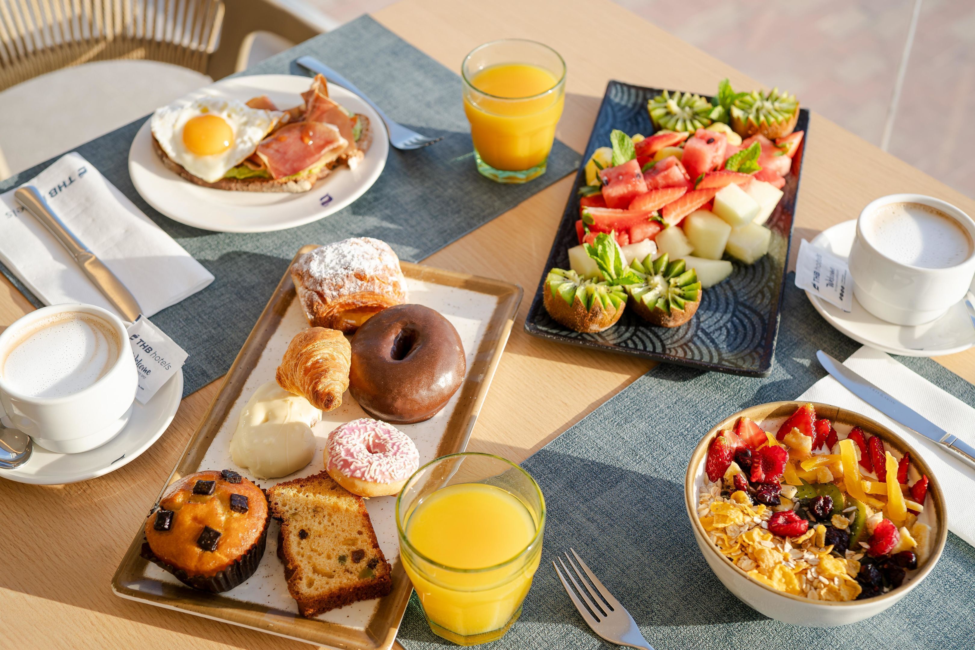 A breakfast setting with various food items and a coffee cup on a table.