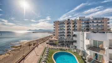 Un hôtel moderne doté d’une piscine, d’une plage et offrant une vue sur la mer.