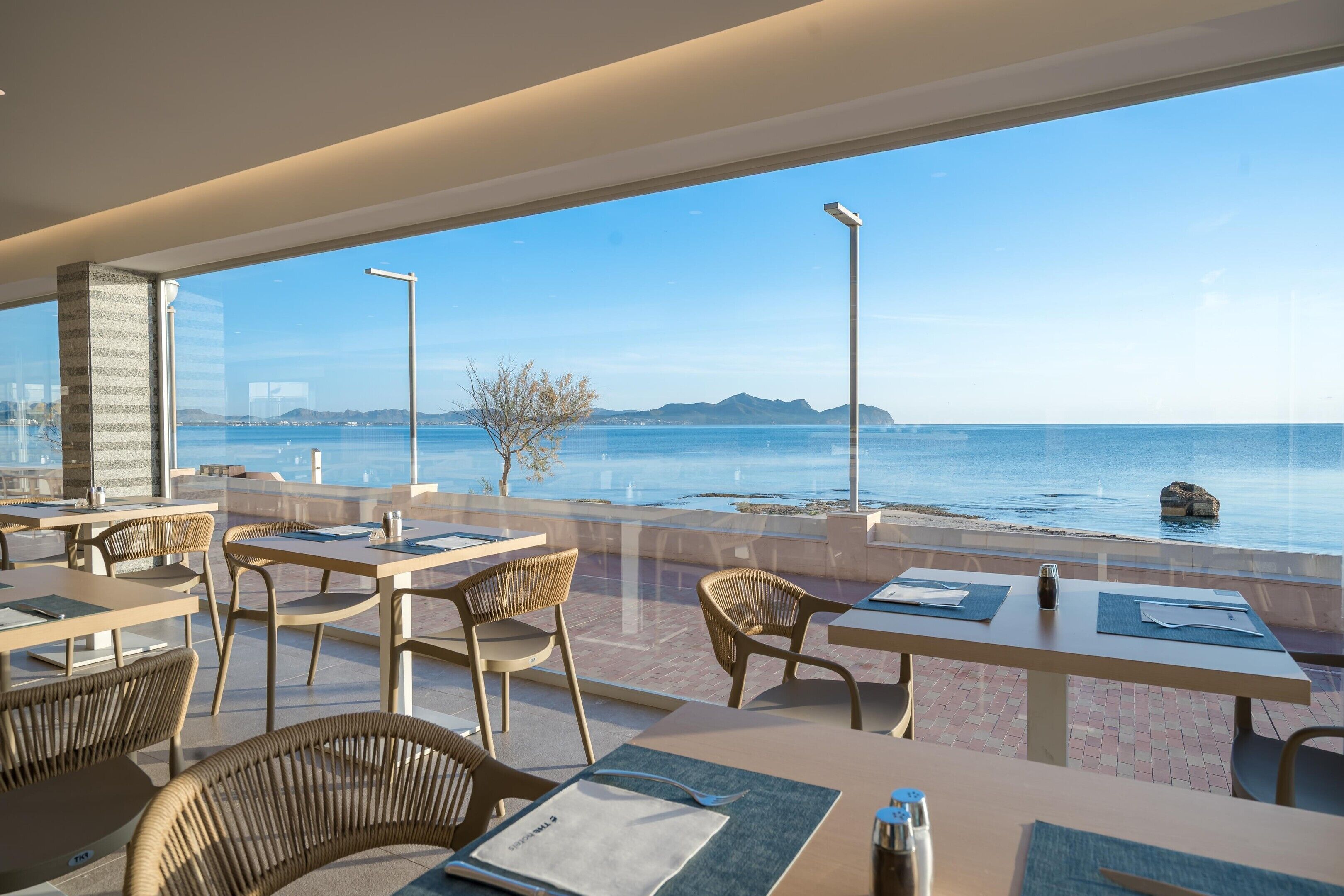 Un restaurant avec une terrasse offrant une vue sur la côte.