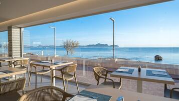 Un restaurant avec une terrasse offrant une vue sur la côte.