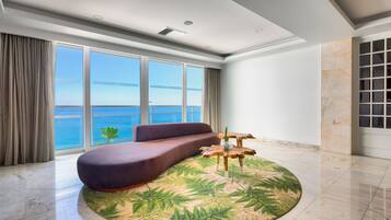 Un salon moderne avec une grande fenêtre, un canapé, un tapis rond et une table basse en bois.