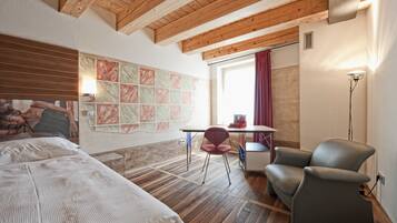 Une chambre à coucher comprenant un lit, un bureau, une chaise et un mur orné d’un motif décoratif.
