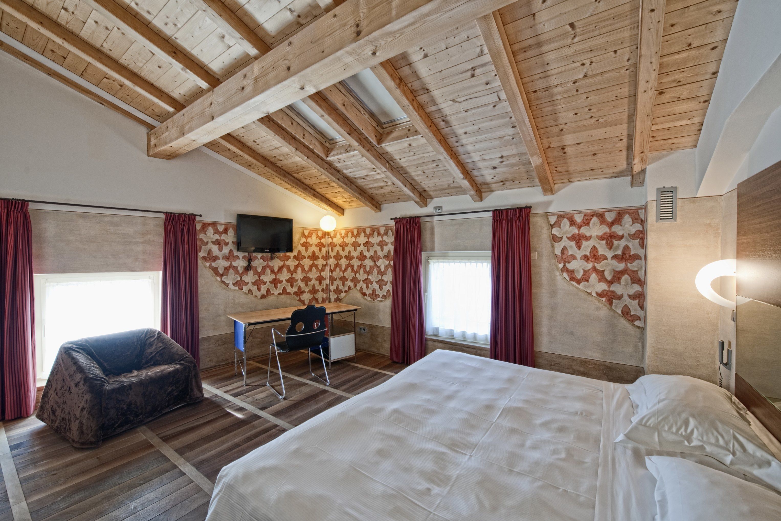 Una habitación con cama, escritorio, silla y sofá.