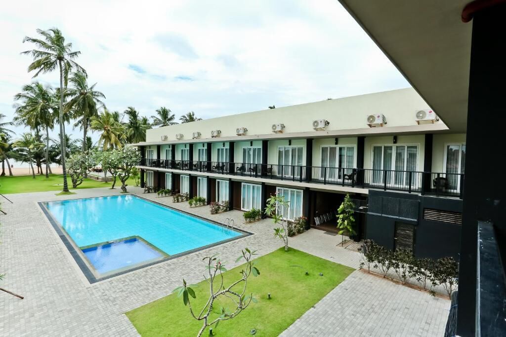 Un hotel con piscina, numerosi balconi e condizionatori.