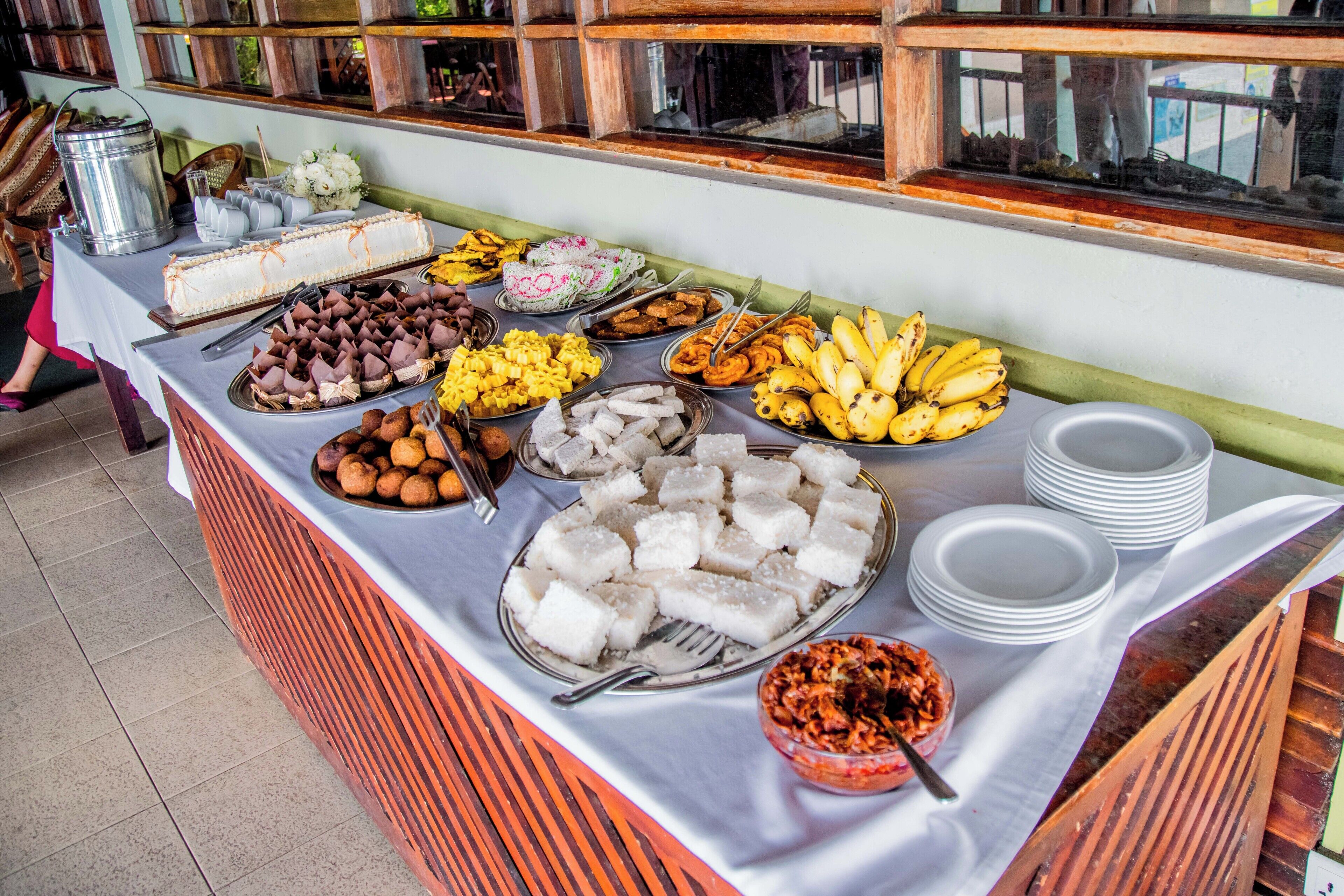 A buffet table with various food items and utensils.