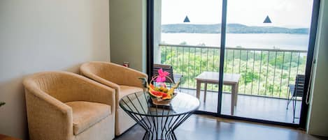 Una habitación con un sofá y una mesa de vidrio con una cesta de frutas.