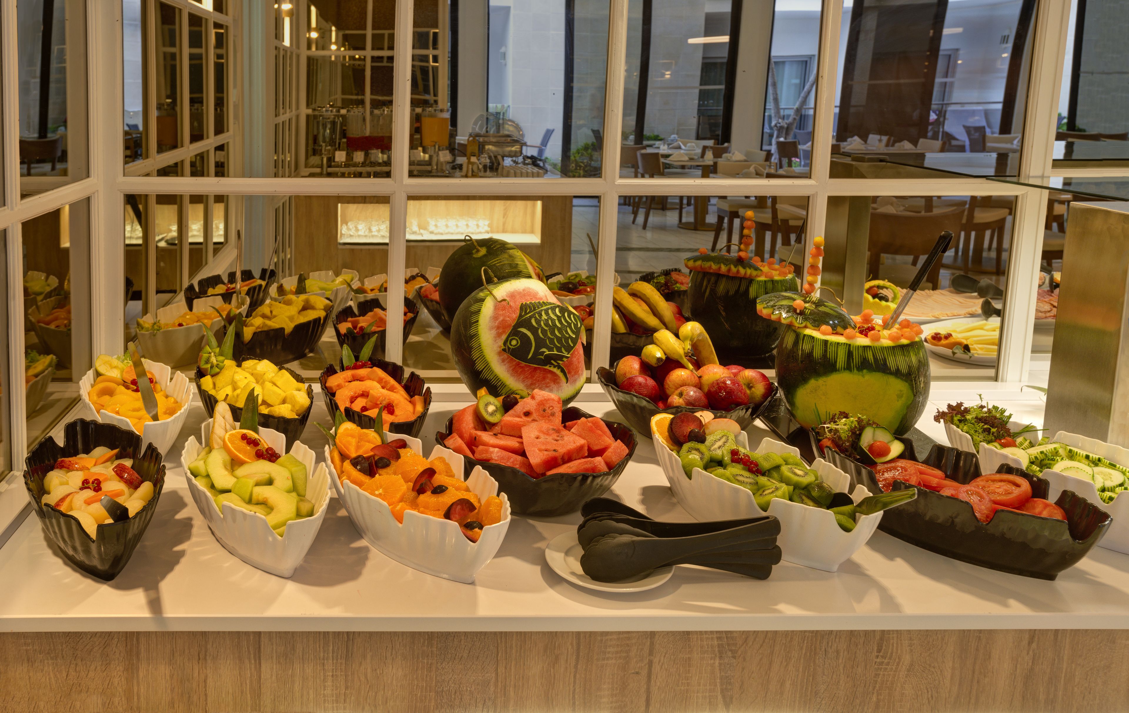 A fruit display in a hotel lobby with various fruits arranged in bowls.