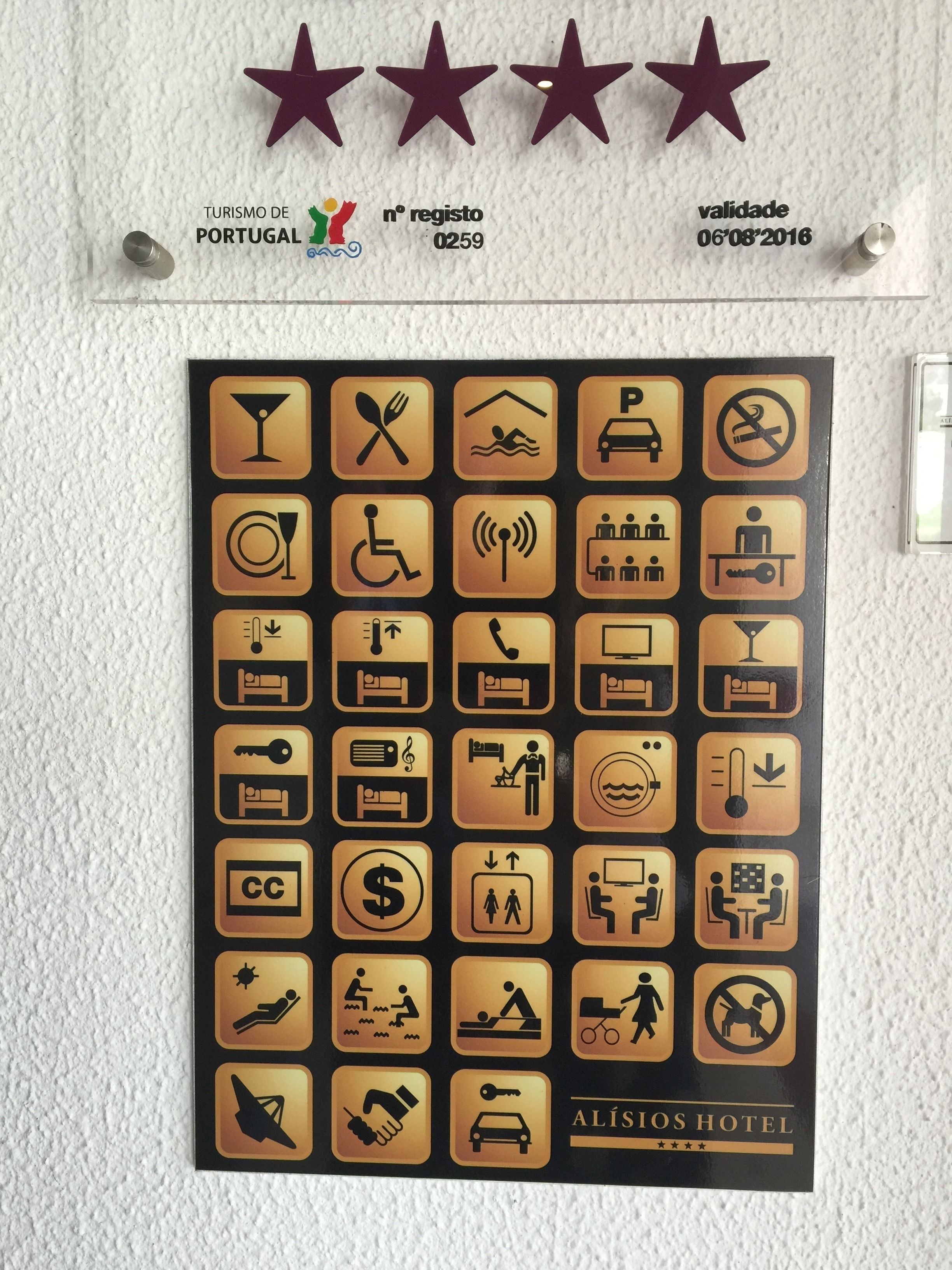 A hotel sign with various symbols indicating amenities such as a swimming pool, parking, and a restaurant.