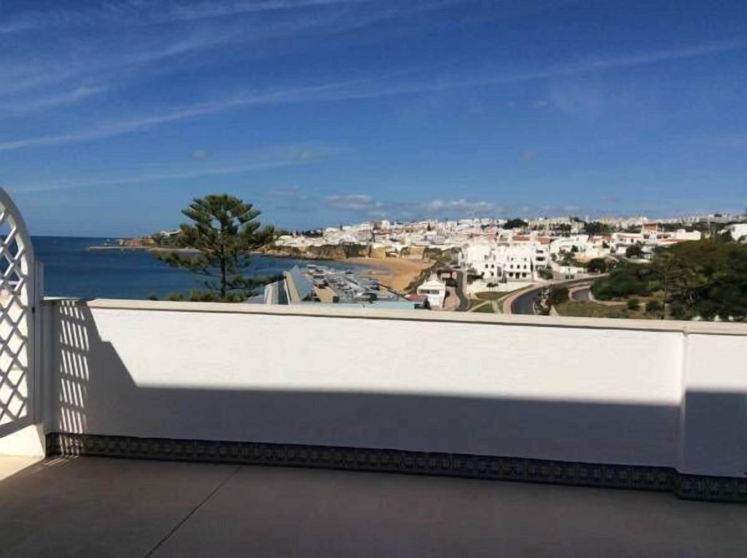 A coastal town with white buildings, a clear blue sky, and a view of the sea.