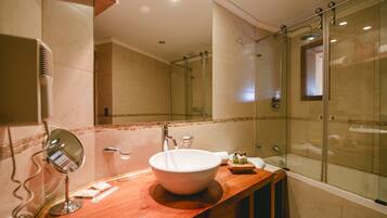 A modern bathroom with a large sink, a glass shower enclosure, and a mirror.