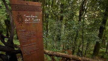 Un cartel en un área boscosa con texto en español.