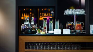 A bar area with various bottles, glasses, and a pitcher.