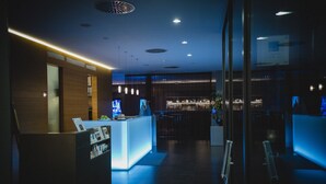 A modern hotel lobby with a reception desk, bar area, and seating. - Hotel Der Blaue Reiter Design- & Tagungshotel (Karlsruhe)