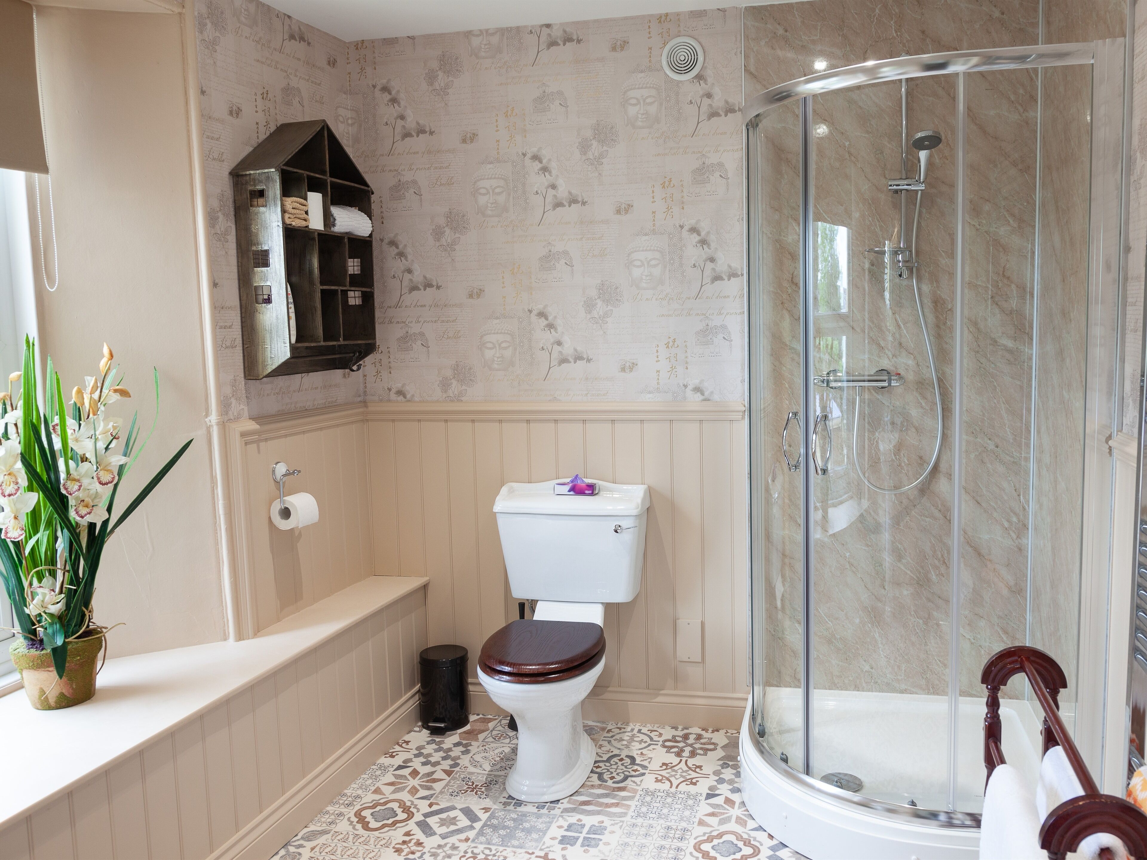 A bathroom with a toilet, a shower enclosure, a bathtub, and a shelf with towels.