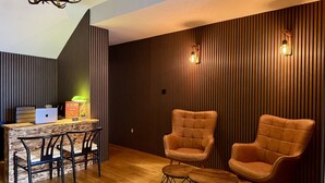A modern living room with a wooden floor, a dining table with chairs, a sofa, and a chandelier. - The Crescent Guest House (York)