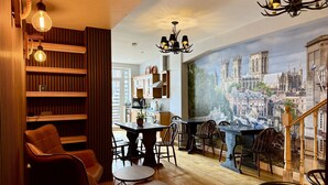 A modern interior with a dining area, wooden shelves, and a mural of a cityscape. - The Crescent Guest House (York)
