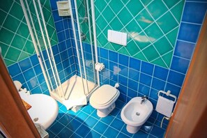 Un baño con cabina de ducha, inodoro y bidé.