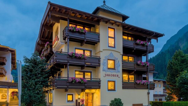 A multi-story building with balconies adorned with flowers, labeled "Jakober." - Hotel Jakober (Tux)